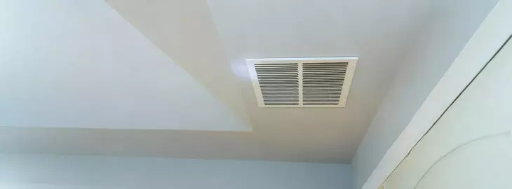 Ducted air conditioning ceiling vent in a modern home interior