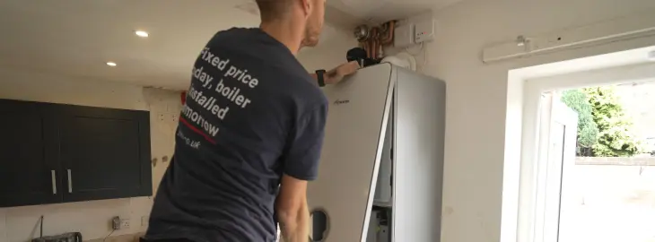 iHeat installer fitting a new Worcester Bosch boiler and connecting the system components during installation.