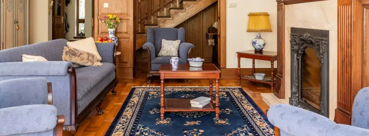 Traditional living room in a large older home with wooden furniture and blue sofas