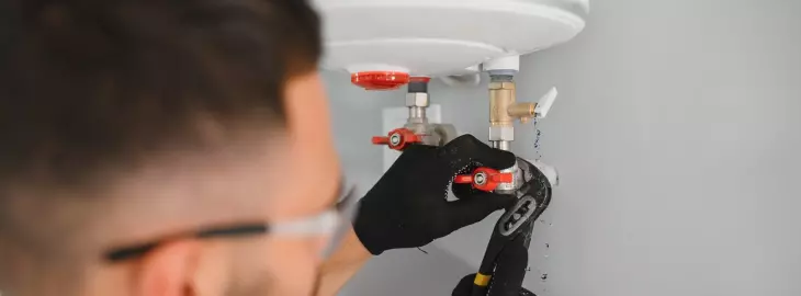 Heating engineer inspecting a combi boiler for internal water leaks.