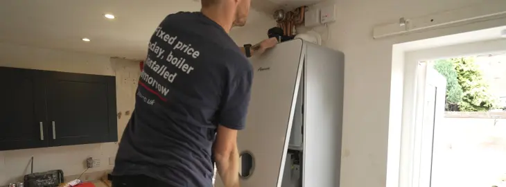 Engineer removing a boiler cover to inspect internal components for a pressure fault.