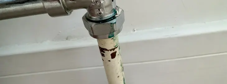 Corrosion and green residue on a radiator pipe joint indicating a possible leak