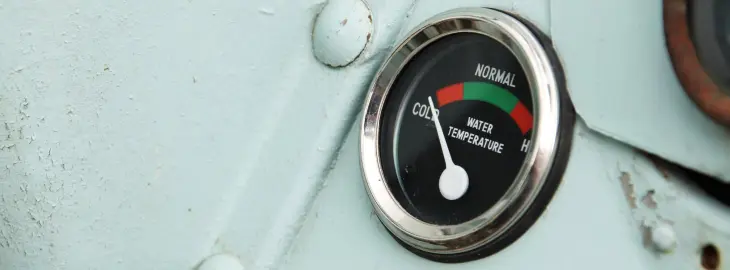 Thermometer gauge showing water temperature fluctuation in a heating system.