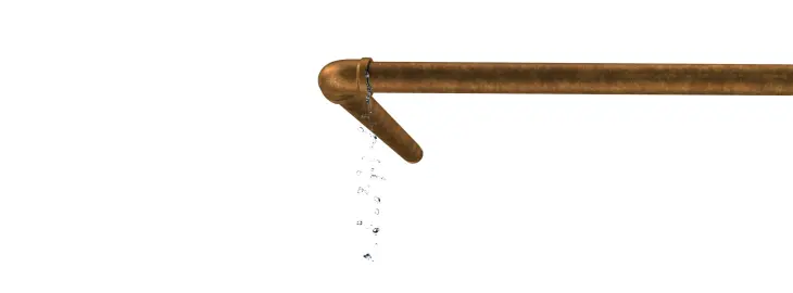 Water dripping from a copper pipe joint indicating a small system leak.