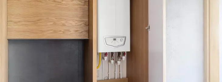 Modern airing cupboard with boiler, pipework and insulated storage space